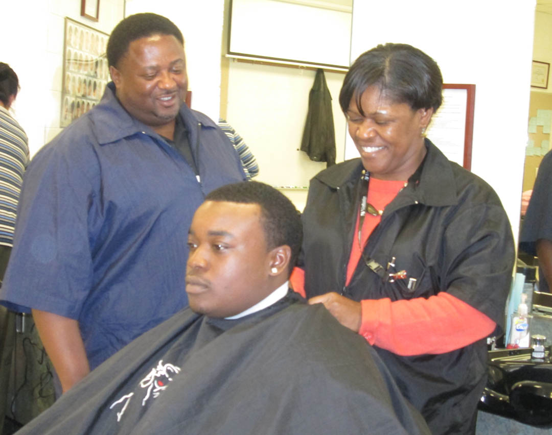 Click to enlarge,  Vanessa Cox as she prepares client Chris Garrett, of Fayetteville, for a haircut. Barbering is one of several programs at the Center, which is located in the rural western part of the county, off N.C. Highway 87. It opened in 2008 and has expanded its program offerings for residents of the western part of Harnett County. For more information on the programs offered by the West Harnett Center, contact Cotton at 919-498-1210 or e-mail at wcotton@cccc.edu. 