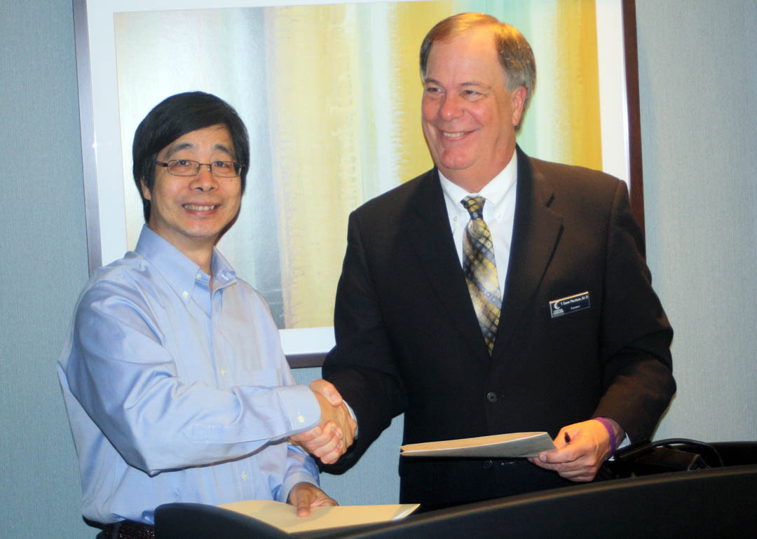 Click to enlarge,  Central Carolina Community College President Dr. T.E. Marchant (right) and Carolina China Council Dr. Lian Xie formalize a partnership between the two institutions. Signed into effect on June 6 at the college's Lee County Campus, the partnership is designed to promote business, culture and education. Event attendees were former North Carolina Sen. Harris Blake and his daughter, Joy Donat; Mayor Cornelia Olive; Bill Horner III, publisher of The Sanford Herald; Dr. Andy Bryan, superintendent-elect of Lee County Schools; Dr. Hong Yang, president of JJY International Information Consulting; CCCC Trustee Jan Hayes, United Way of Lee County executive director; and CCCC personnel Dr. Lisa Chapman, executive vice president for instruction; Ling Huang, Confucius Classroom instructor; and Jon Matthews, dean of University Transfer and Health Science. For more information about the Carolina China Council, visit http://carolina-chinacouncil.org. For more information about Central Carolina Community College's Confucius Classroom, visit www.cccc.edu/confucius. 