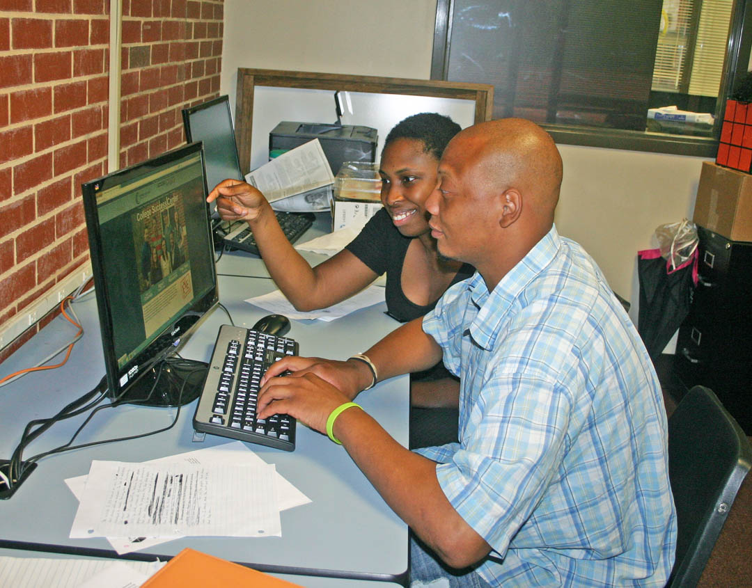 Click to enlarge,  Spencer Bridges (front), of Sanford, a Central Carolina Community College Business Administration major, works with Torry Reynolds, lead success coach, at the college's new College Success Center. 