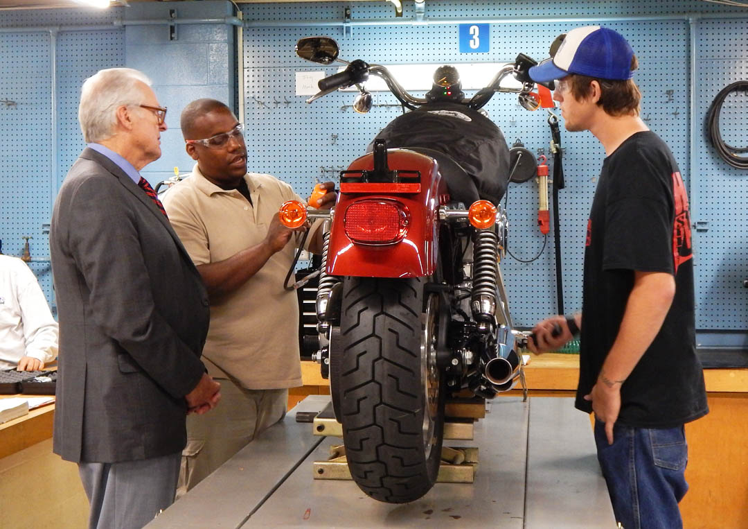 Click to enlarge,  North Carolina State Sen. Ronald Rabin (left), a retired U.S. Army colonel, visited Central Carolina Community College's Lee County Campus Sept. 17 to see some of the vocational programs that veterans are enrolled in and to speak to the Veterans Club. Motorcycle Mechanics student Robert Miller (second from left), of Hoke County, who retires from the Army in October, and student Kenneth Kennedy, of Harnett County, demonstrate a leak-down test on a Harley Davidson engine. The vocational training for in-demand careers and the support services the college offers veterans impressed him. For information about veterans' services at CCCC, call Tracey Gross, Veterans Affairs Coordinator, at 919-718-7233 or email at tgross@cccc.edu.  