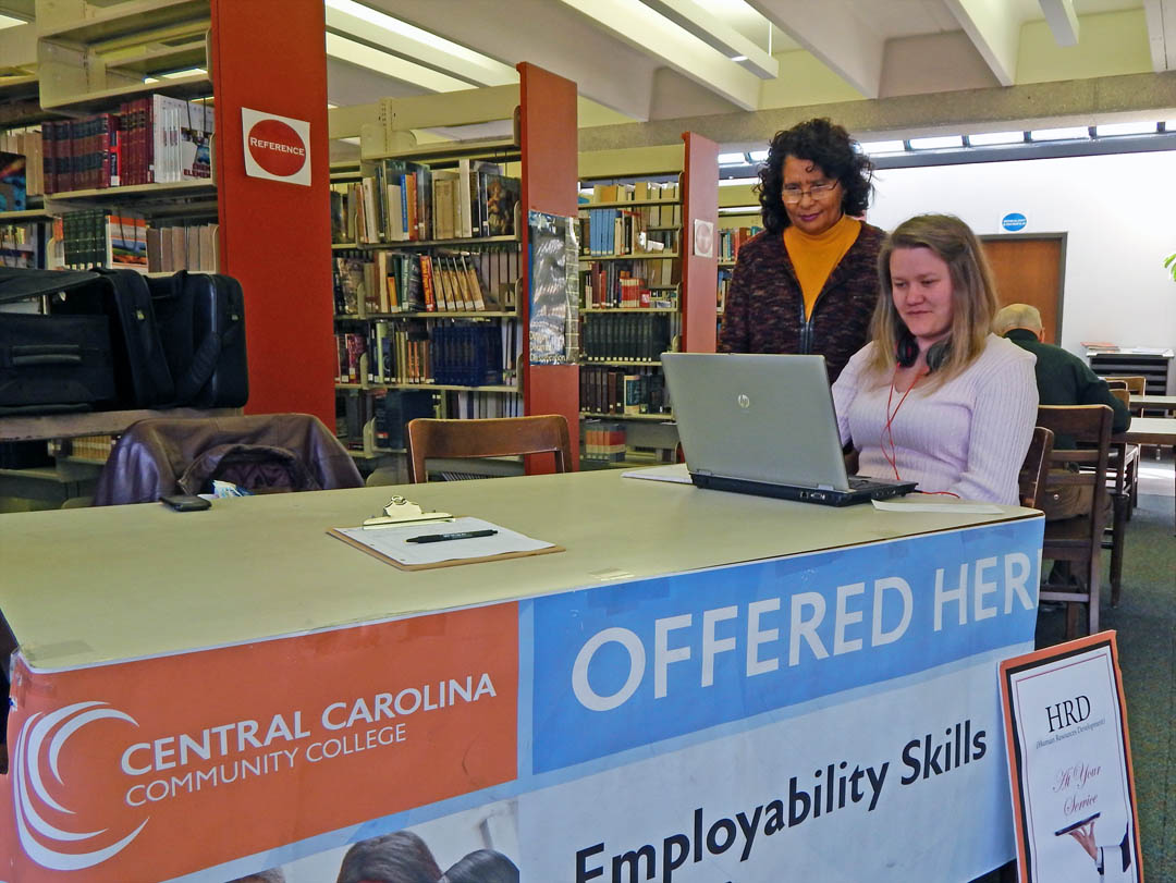 Click to enlarge,  Laurinda Southerland (left), Central Carolina Community College Human Resources Development instructor, assists Lydia Russell, of Sanford, in refreshing her skills in preparation for a Career Readiness Certification exam. They are at the college's new Career Readiness Lab in Lee County's Suzanne Reeves Library, 107 Hawkins Ave. A kickoff for the new lab will be held from 11 a.m. to 4 p.m. Wednesday, Jan. 29. The public is invited. The lab, part of the college's Continuing Education Department, offers skill training and opportunities in job searching, exploring labor market information, Career Readiness Certification preparation and exams, and preparing cover letters, resumes, thank-you letters, and online applications. The lab is open on a walk-in basis from 9 a.m.-2 p.m. Mondays and Tuesdays, and 11 a.m.-4 p.m. Wednesdays. Registration on-site is required to use the resources. Fee waivers are available for those who qualify as unemployed or underemployed. For more information, contact Crystal McIver, 919-777-7798 or cmciver@cccc.edu. 