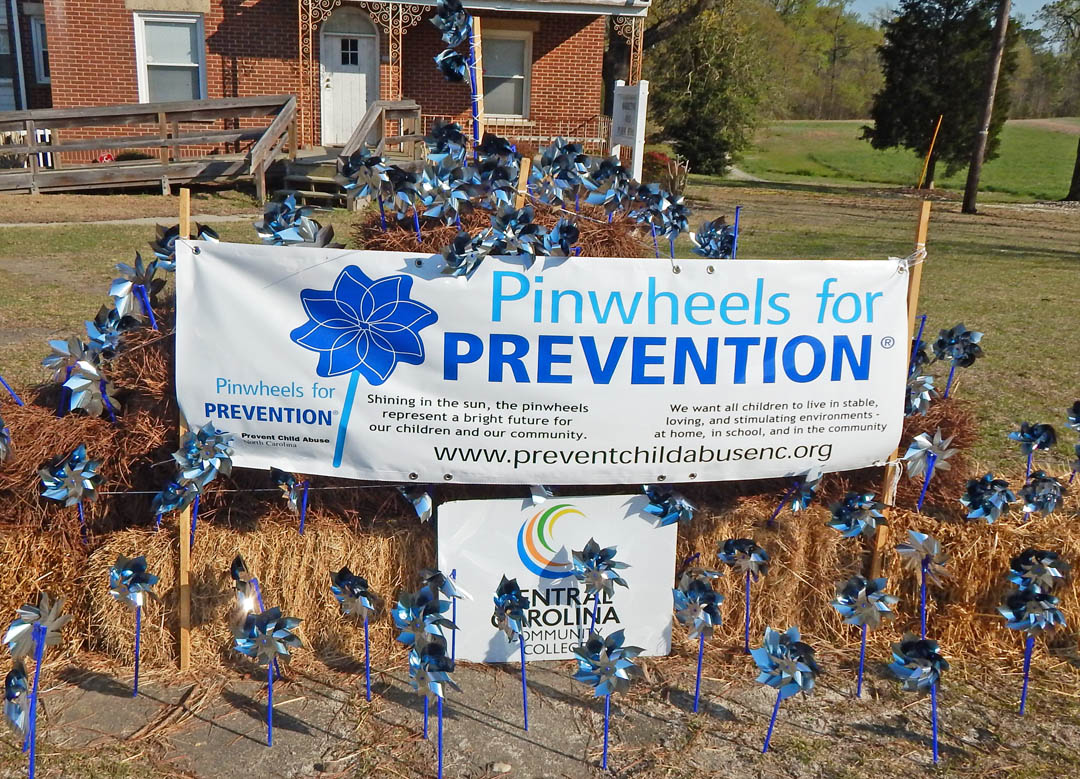 Click to enlarge,  April is national Child Abuse Prevention Month and pinwheels spin in the breeze on Central Carolina Community College's Lee County Campus, symbolizing the beauty and joy of childhood innocence and the hope for a bright future for all children. CCCC's Early Childhood Education students set up the display across Kelly Drive from the campus' main entrance. It will be on view through May 5. The students will also hold a bake sale at the campus from 10 a.m. to 2 p.m. on Tuesday, April 22 to raise funds to donate to Prevent Child Abuse North Carolina (PCANC). All items will be $1. They will also distribute literature and information about child abuse prevention and encourage donations to PCANC. PCANC accepts donations and distributes the money to organizations that support the development of safe stable, nurturing relationships for children in their families and communities to prevent child abuse and neglect. For more information about ECE programs at the college or the students' project, contact David Leperi at dlepe151@cccc.edu. All donations will be processed through the CCCC Foundation, foundation@cccc.edu, and dispensed to PCANC. For more information about PCANC, visit its website, www.preventchildabusenc.org. 