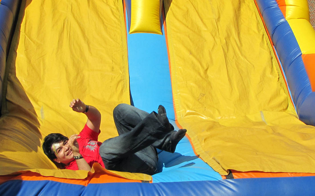 Click to enlarge,  Edgar Romero Cruz, a student at Central Carolina Community College, rides on an inflatable slide during the recent Fall Activity Day on the Chatham County Campus. The Student Government Association holds an Activity Day at the college's Chatham, Harnett and Lee Campuses to give the students an opportunity to relax, enjoy themselves, meet other students in a casual setting, and discover that fun is a part of the community college experience. 