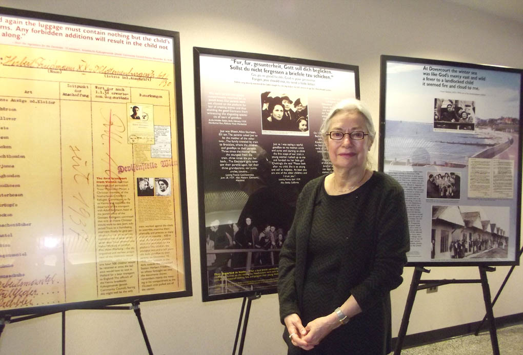 Click to enlarge,  Mrs. Renee Fink, a Holocaust survivor who was guest speaker for Central Carolina Community College's Second Annual Holocaust Remembrance Event, stands by a portion of the traveling exhibit 'The Kindertransport Journey: Memory into History,' was which was made available thanks to the North Carolina Council on the Holocaust. 