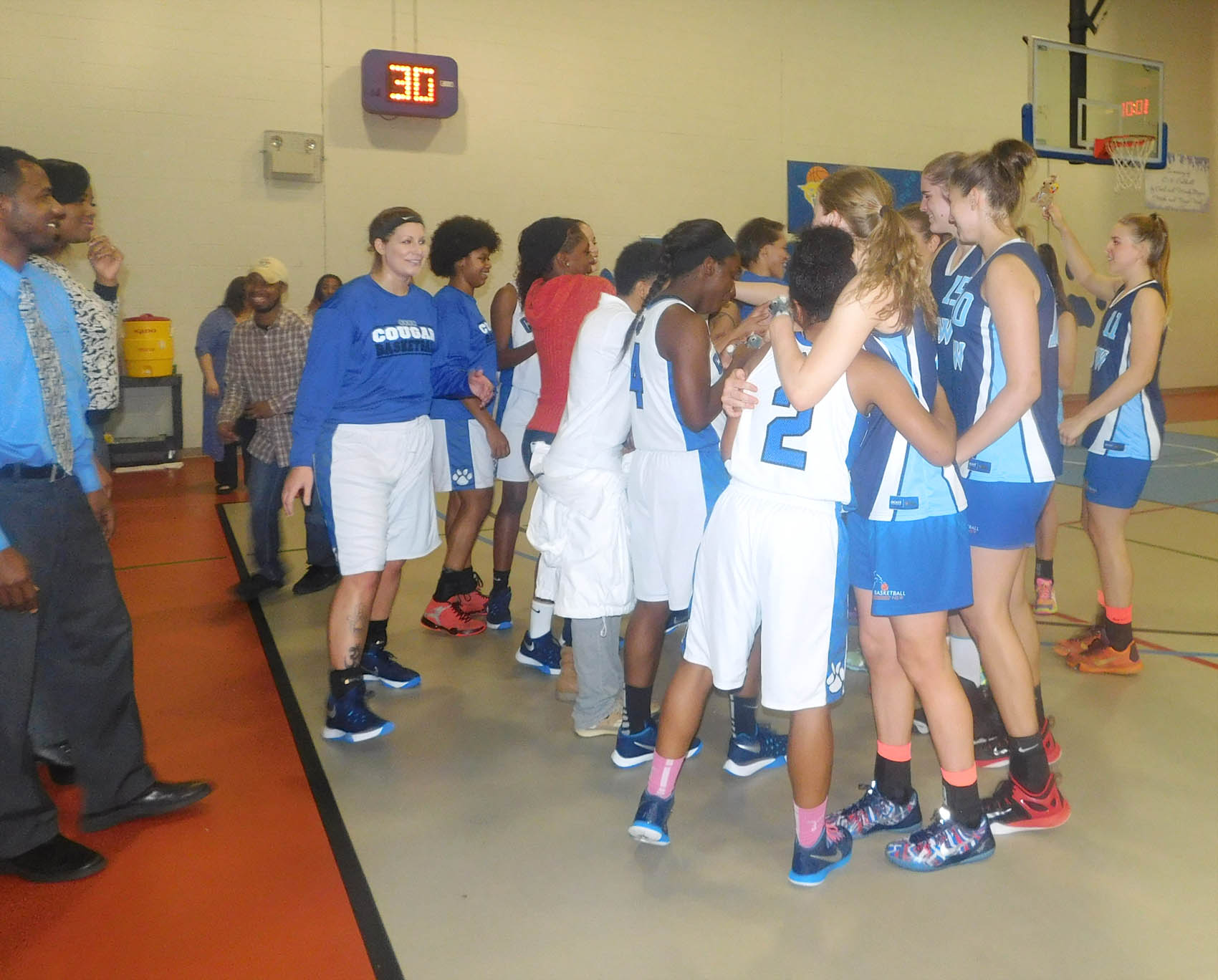 Click to enlarge,  Members of the Central Carolina Community College and New South Wales, Australia, basketball teams share greetings before the start of their game. 