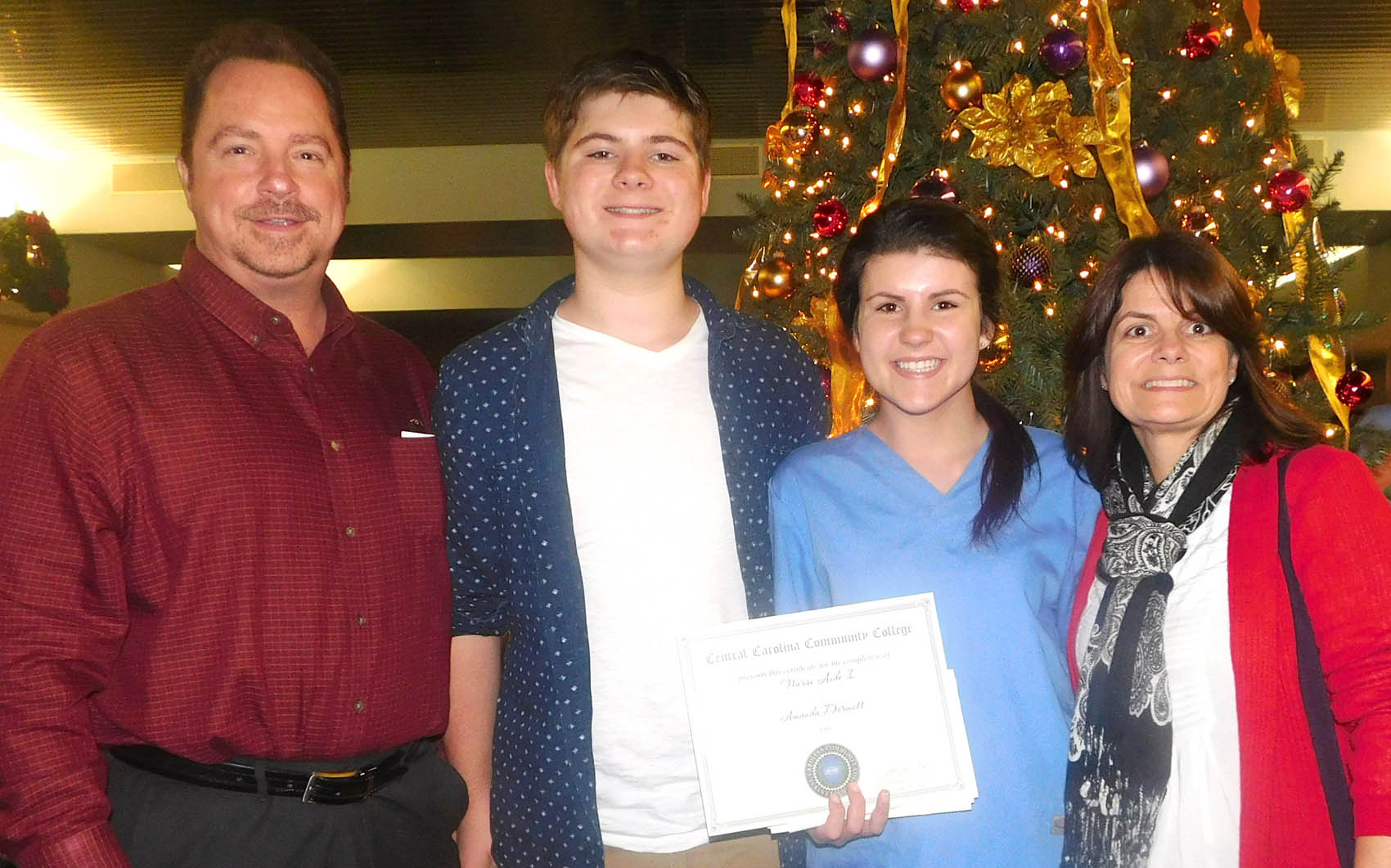 Click to enlarge,  Amanda Dermott, of Dunn, and her family celebrate her Nurse Aide I certification at the Central Carolina Community College Continuing Education medical program graduation. 'Tonight is great. It's the start of my nursing career,' said Dermott. The graduation event was held Dec. 10 at the Dennis A. Wicker Civic Center in Sanford. For more information about Continuing Education medial programs, call the CCCC Economic and Community Development Division Student Support Center at (919) 718-7500. 