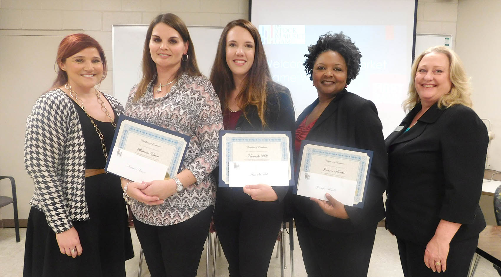 Click to enlarge,  Central Carolina Community College Business Technologies Instructor Amber Thomas (left) is pictured with three of her students -- Shannon Eason, Amanda Holt, and Jennifer Womble - who comprised the winning collegiate team in recent competition of the Stock Market Game. Pictured at right is Sandy Wheat, Executive Director of the N.C. Council on Economic Education. 