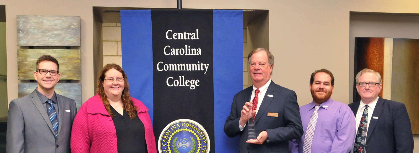 Click to enlarge,  Central Carolina Community College has won a first-place national Paragon Award from the National Council for Marketing &amp; Public Relations (NCMPR) in the category of Government Relations or Community Relations Project. CCCC President Dr. T. Eston Marchant (middle) holds the Paragon Award. Joining Dr. Marchant in the photo are members of the CCCC Marketing and Public Affairs staff, left to right: Neil McGowan, Graphic Artist &amp; Multimedia Specialist; Marcie Dishman, Associate Vice President of Marketing and Human Resources; Dr. Marchant; Morgan Steele, Director of Web and Creative Strategy; and R.V. Hight, Director of Communications. 