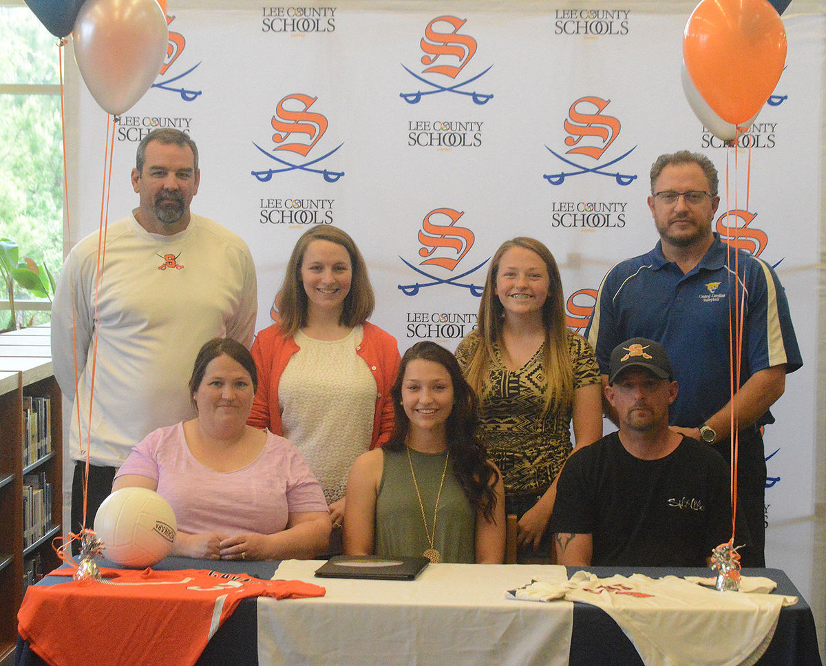 Click to enlarge,  Andrew Giermak | The Sanford Herald   Southern Lee senior Tara Way, seated center, signed a volleyball letter of intent with Central Carolina Community College Thursday during a ceremony at the school. With her is, seated, her parents Laurie and Chris, standing from left, Southern Lee athletic director Don Simon, Southern Lee volleyball head coach Alyson Cochrane, Tara's sister Kiley, and CCCC volleyball head coach Bill Carter. 