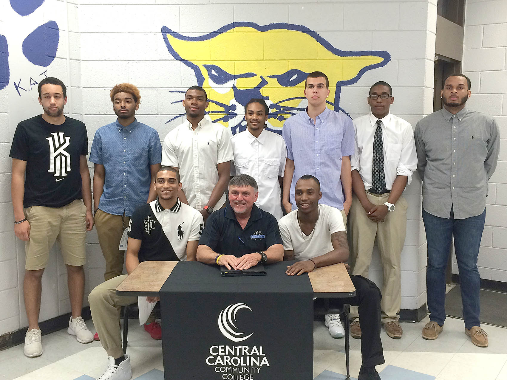Click to enlarge,  Andrew Giermak, The Sanford Herald   Central Carolina Community College welcomed nine new basketball recruits as they signed with the Cougars April 27. Seated from left is DaShaun Boswell, head coach Doug Connor, Jared Foster, standing from left is Brice Harrison, Jamal Shuford, Avion Jordan, Greg Patterson, Dalton Thomas, Isaiah Monroe, and Jordan Lunsford. 
