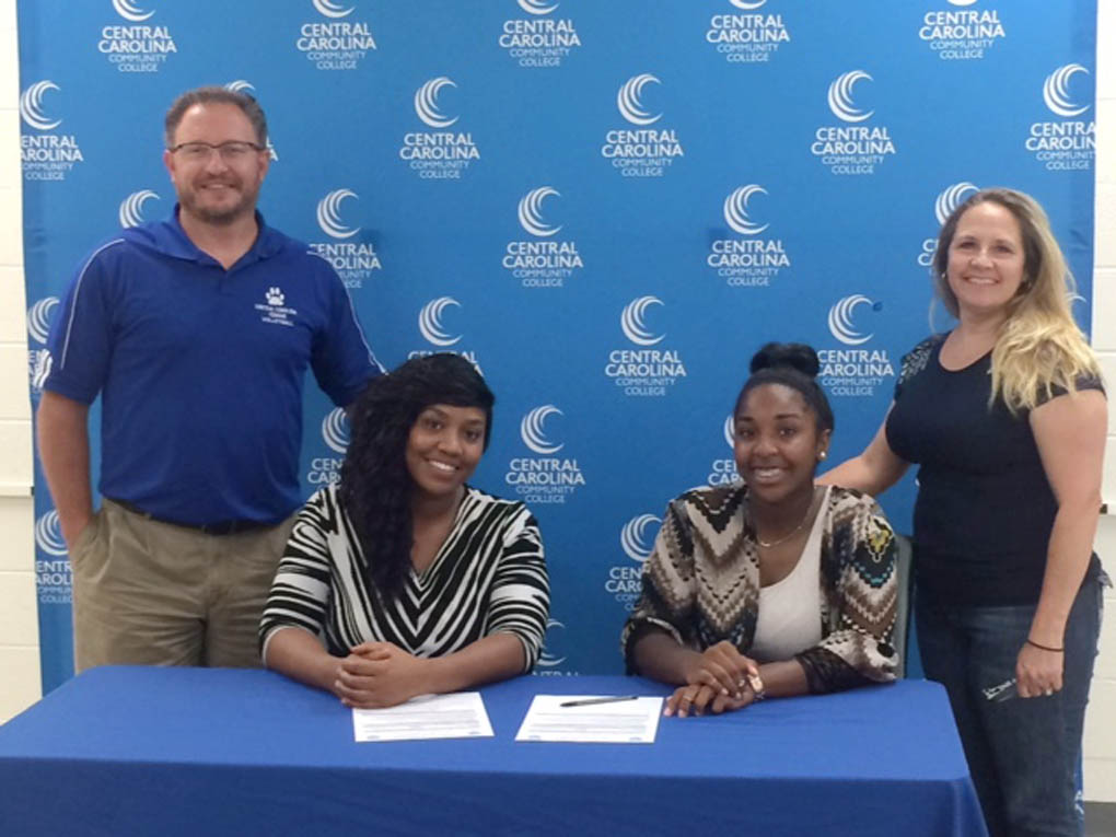 Click to enlarge,  Grace Christian's Charity Taylor, seated right, signed to attend and play volleyball at Central Carolina Community College. 