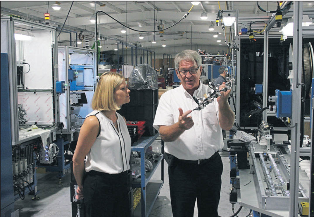 Click to enlarge,  Zachary Horner, The Sanford Herald. Catherine Truitt (left), N.C. Gov. Pat McCrory's senior education advisor, and Mertek Solutions president Jerry Pedley inspect a fuel supply part made by a Mertek-designed and manufactured assembly system. Truitt visited the factory and Central Carolina Community College during a trip to Lee County. 