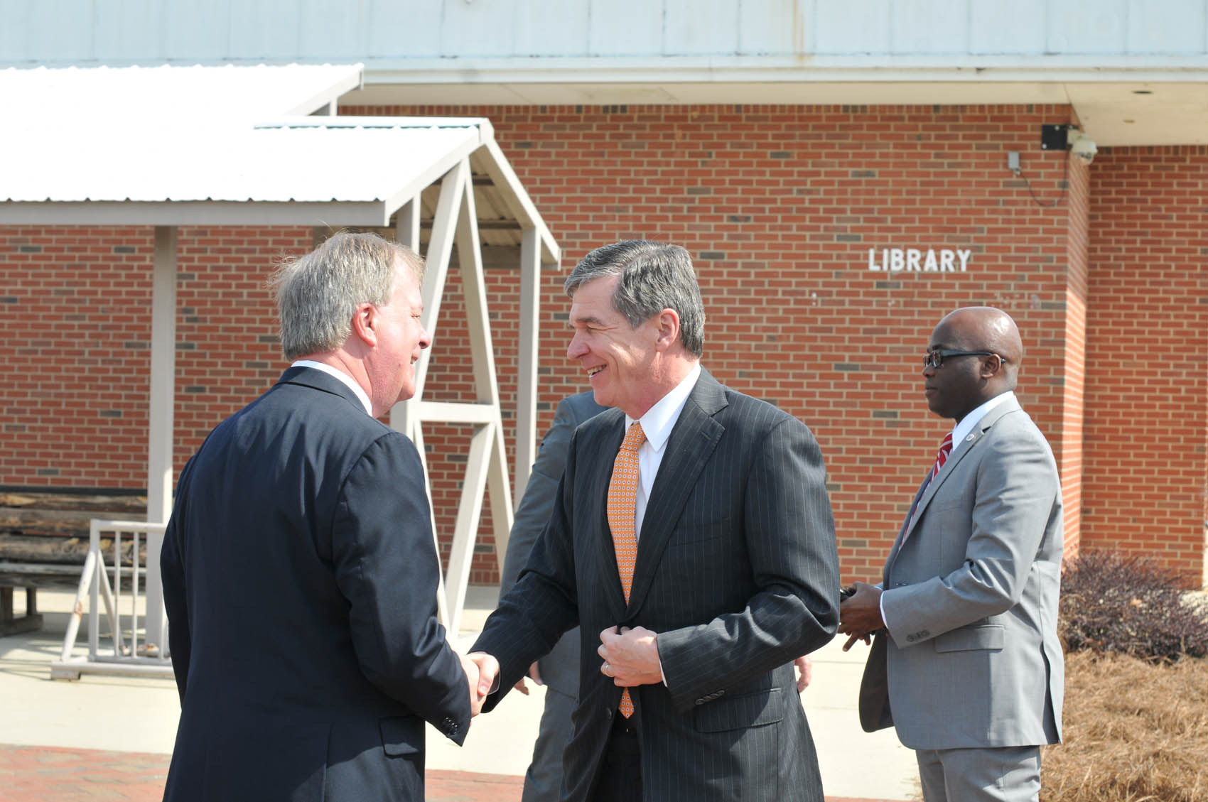 Click to enlarge,  Central Carolina Community College President Dr. T. Eston Marchant (left) greets North Carolina Gov. Roy Cooper upon his arrival to the CCCC Lee Main Campus on Wednesday, April 12. 