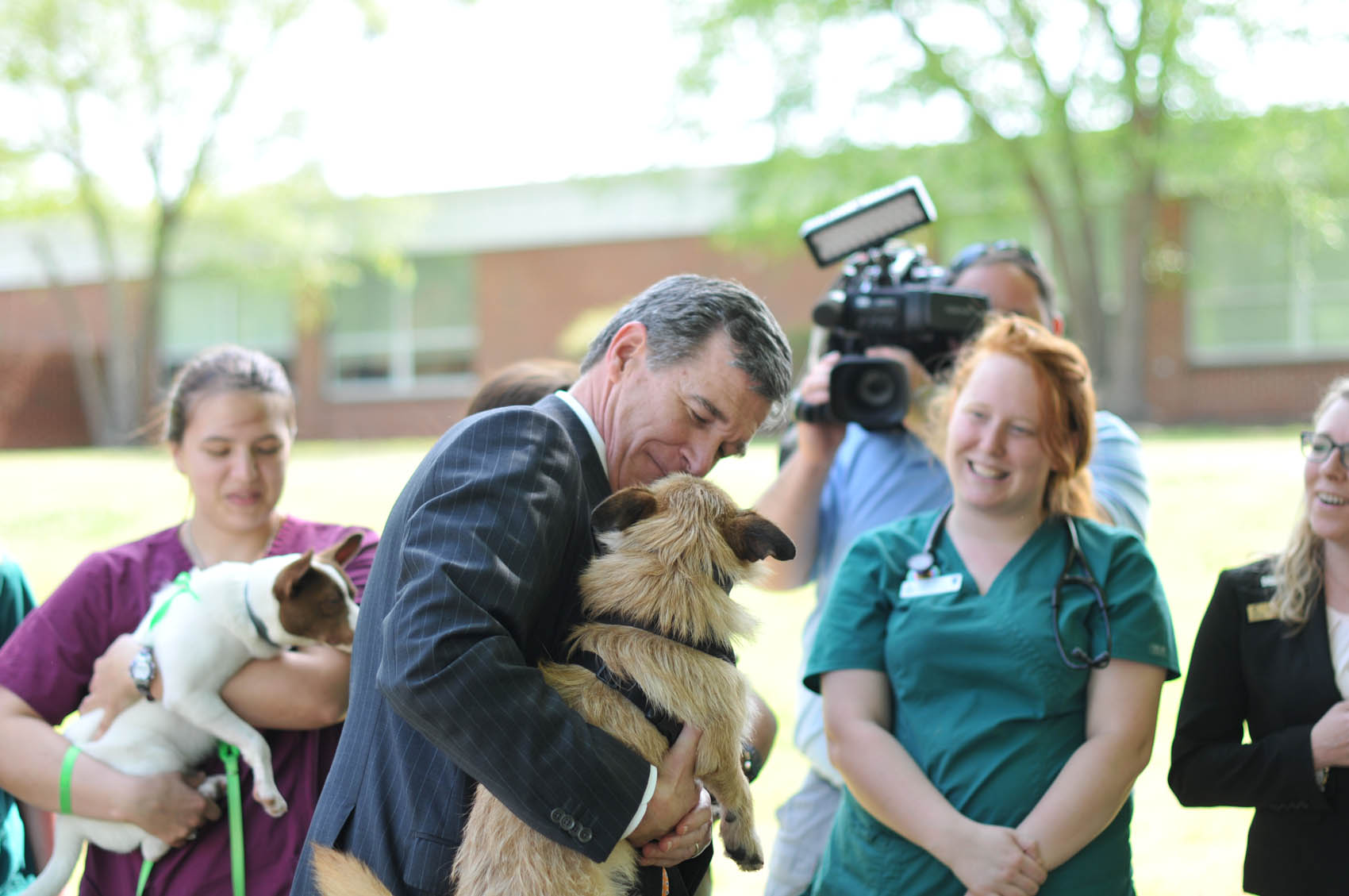 Click to enlarge,  North Carolina Gov. Roy Cooper holds a dog from Central Carolina Community College's Veterinary Medical Technology program on Wednesday, April 12, at the CCCC Lee Main Campus. 