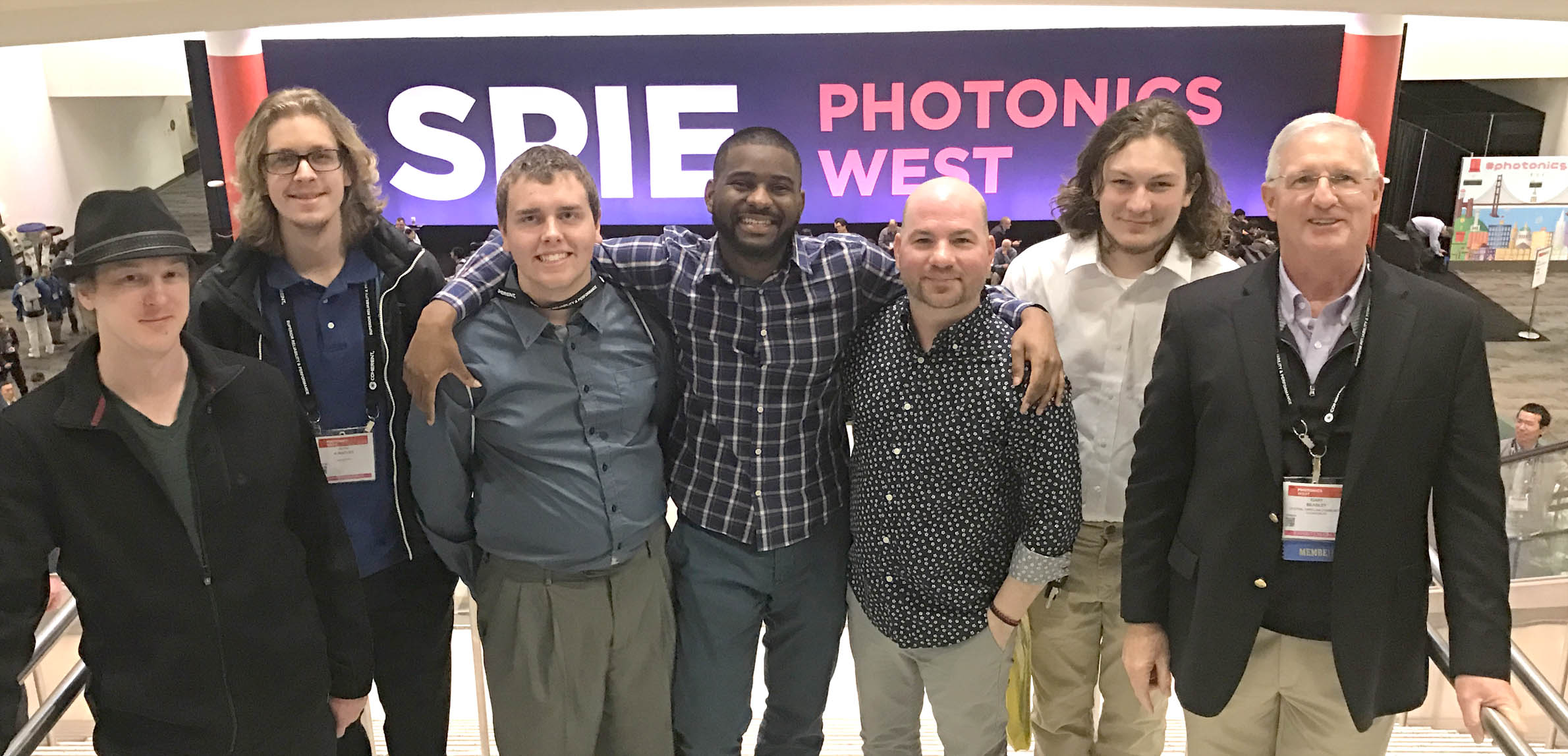 Click to enlarge,  Second-year students in the Laser and Photonics Technology program at Central Carolina Community College attended the 2018 SPIE Photonics West Convention in San Francisco. Pictured are, left to right: Michael Kropp, Seth Kuenzler, Derrick Kuhl, Jamal Robinson, Nickolas Jorgenson, Darin Anderson, and Gary Beasley (Lead Instructor). 