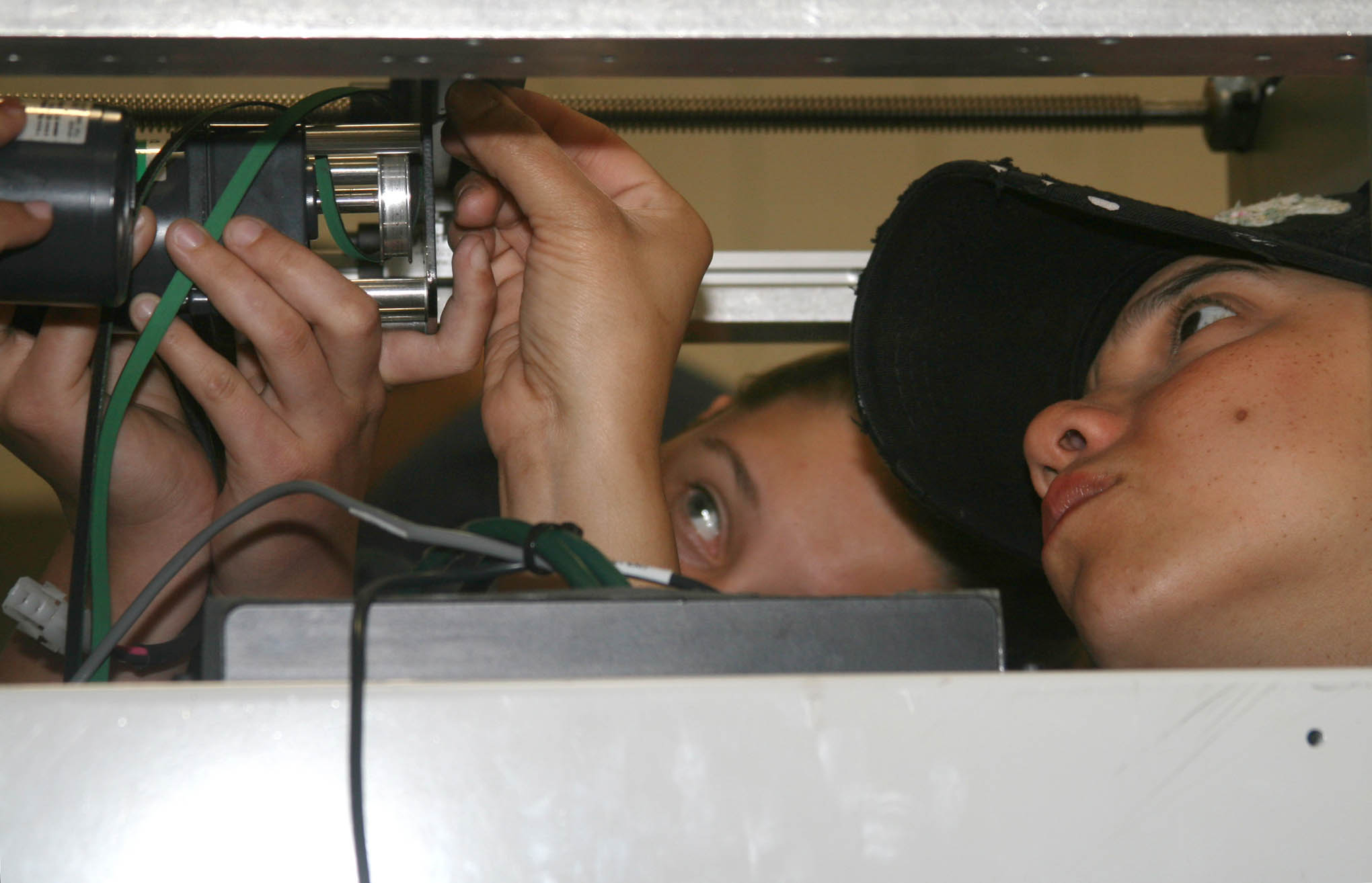 Click to enlarge,  Recently hired machine builders Claudia Maddox, left, and Yesenia Alicea get close to the equipment while installing electronics in an automated machine during an innovative training course developed by Central Carolina Community College and Conveyor Tech. 