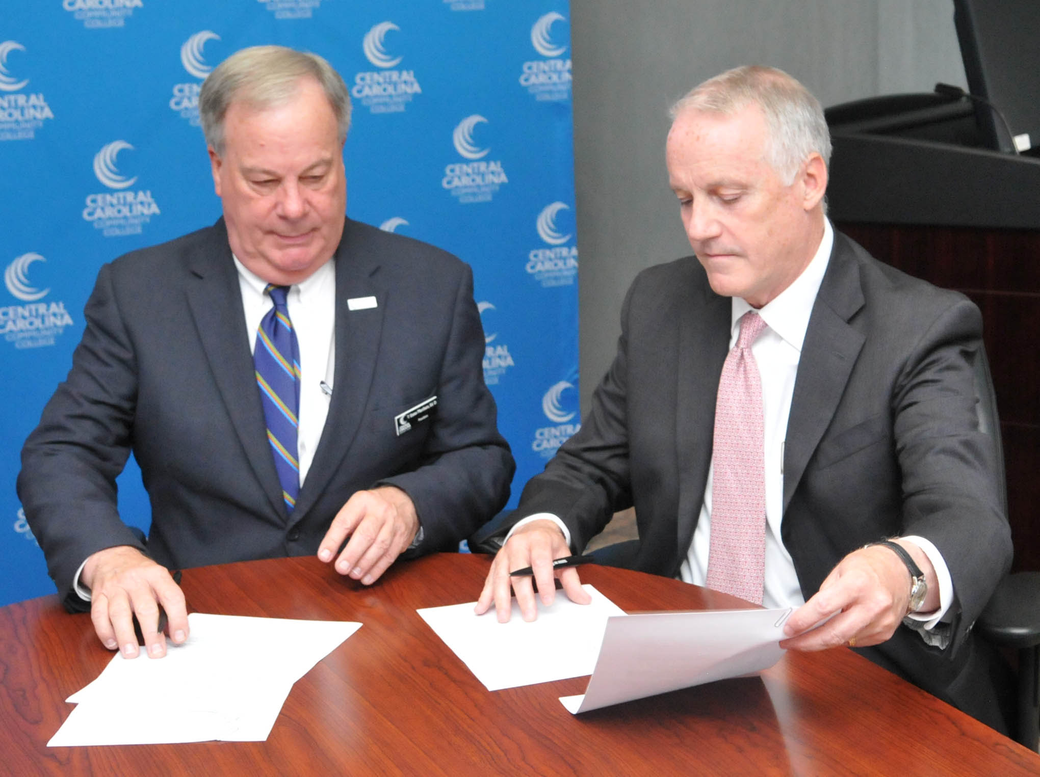 Click to enlarge,  Central Carolina Community College President Dr. T. Eston Marchant (left) and Dr. Louis D. Hunt, Senior Vice Provost for Enrollment Management at NC State University, sign a Memorandum of Understanding that promotes both associate degree and baccalaureate degree completion by giving guaranteed admission to N.C. State for CCCC students who meet the conditions of the program. 