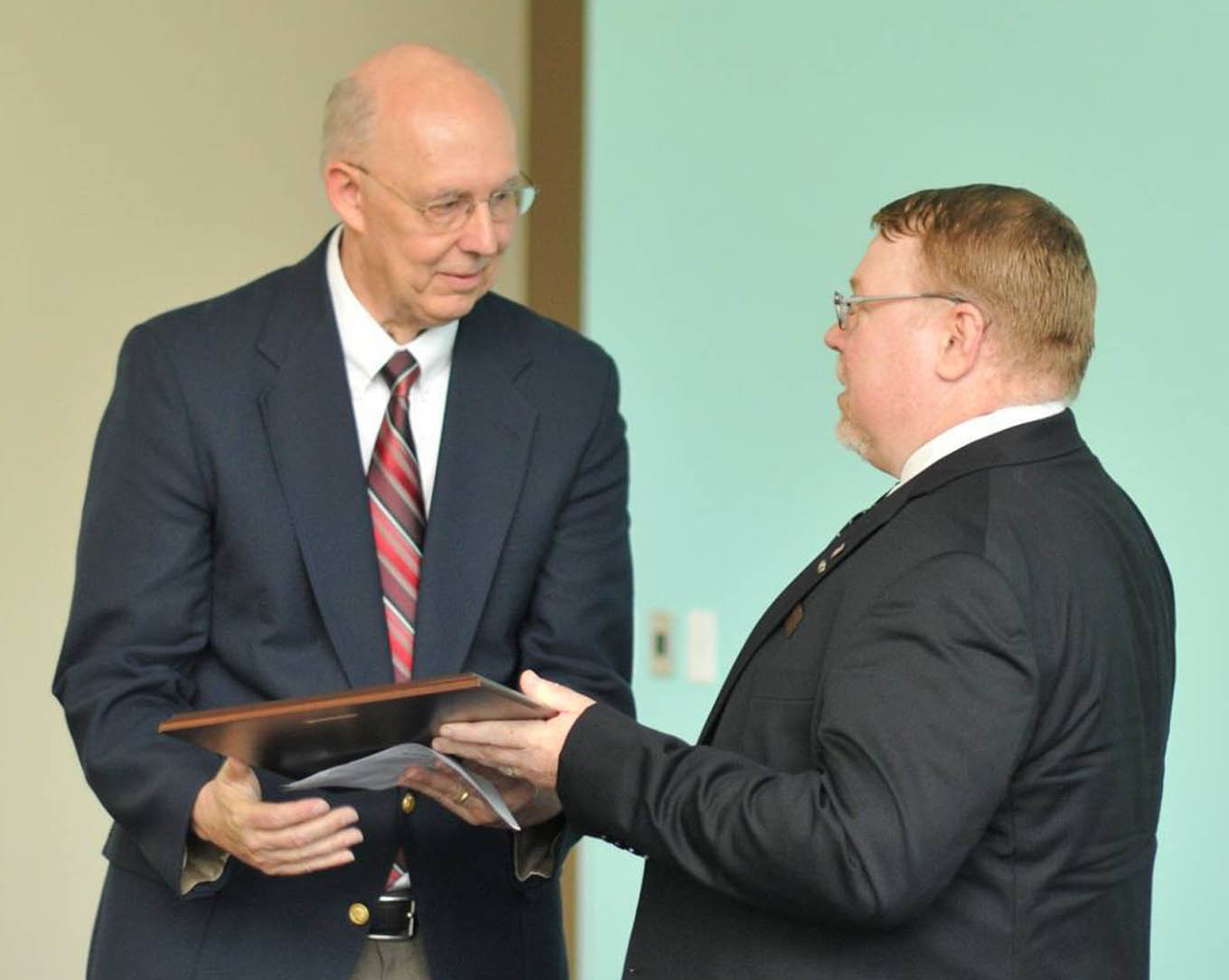 Click to enlarge,  Dr. Mark Glaser, who has been Medical Director since the inception of the Central Carolina Community College Paramedic program, received a plaque from Richard Stump, Lead Paramedic Instructor, during the CCCC Emergency Medical Services graduation on June 19 at the CCCC Harnett Health Sciences Center in Lillington. 