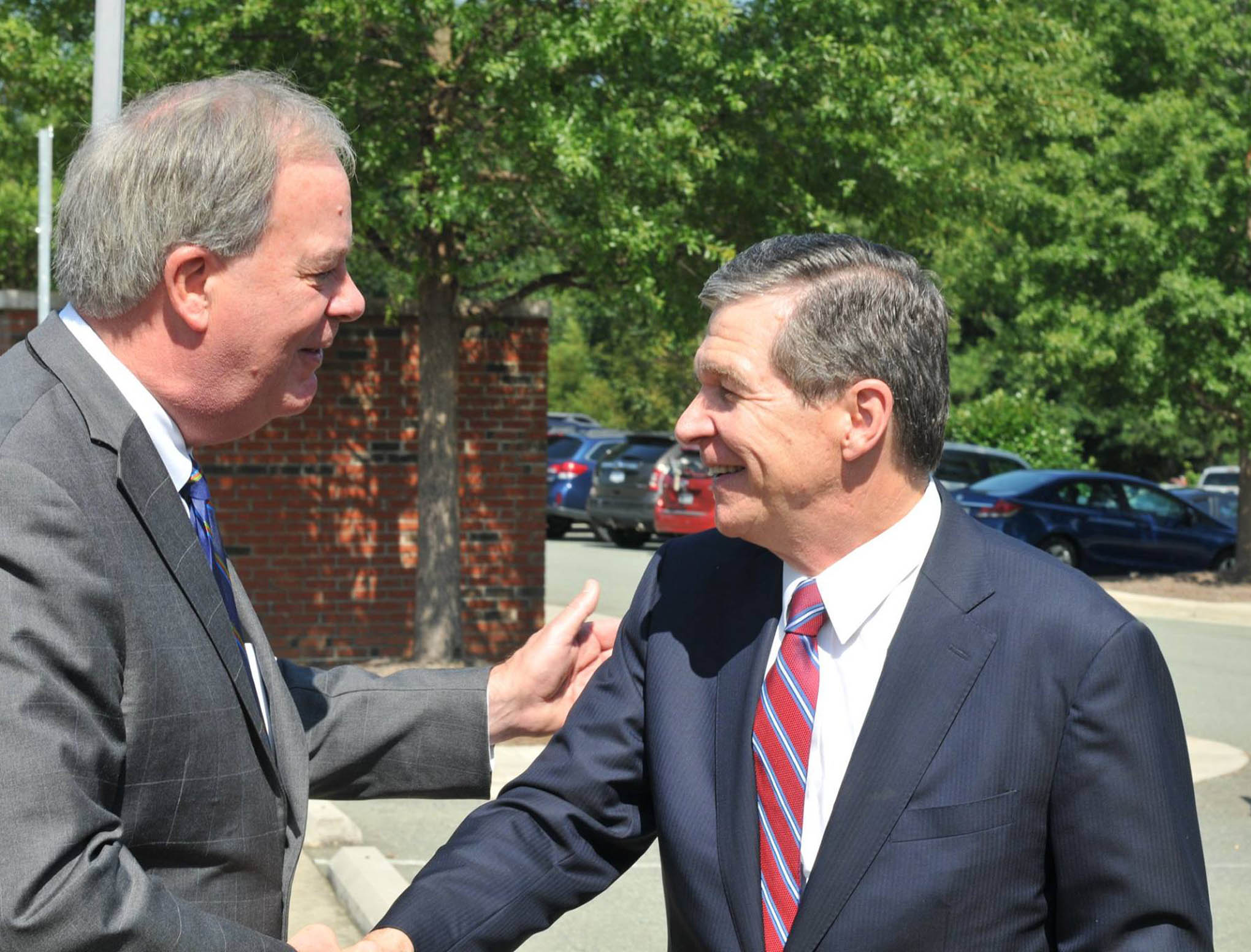 Click to enlarge,  Central Carolina Community College President Dr. T. Eston Marchant (left) greets N.C. Gov. Roy Cooper as he arrived at the CCCC Chatham Main Campus in Pittsboro on Thursday, Aug. 23. 