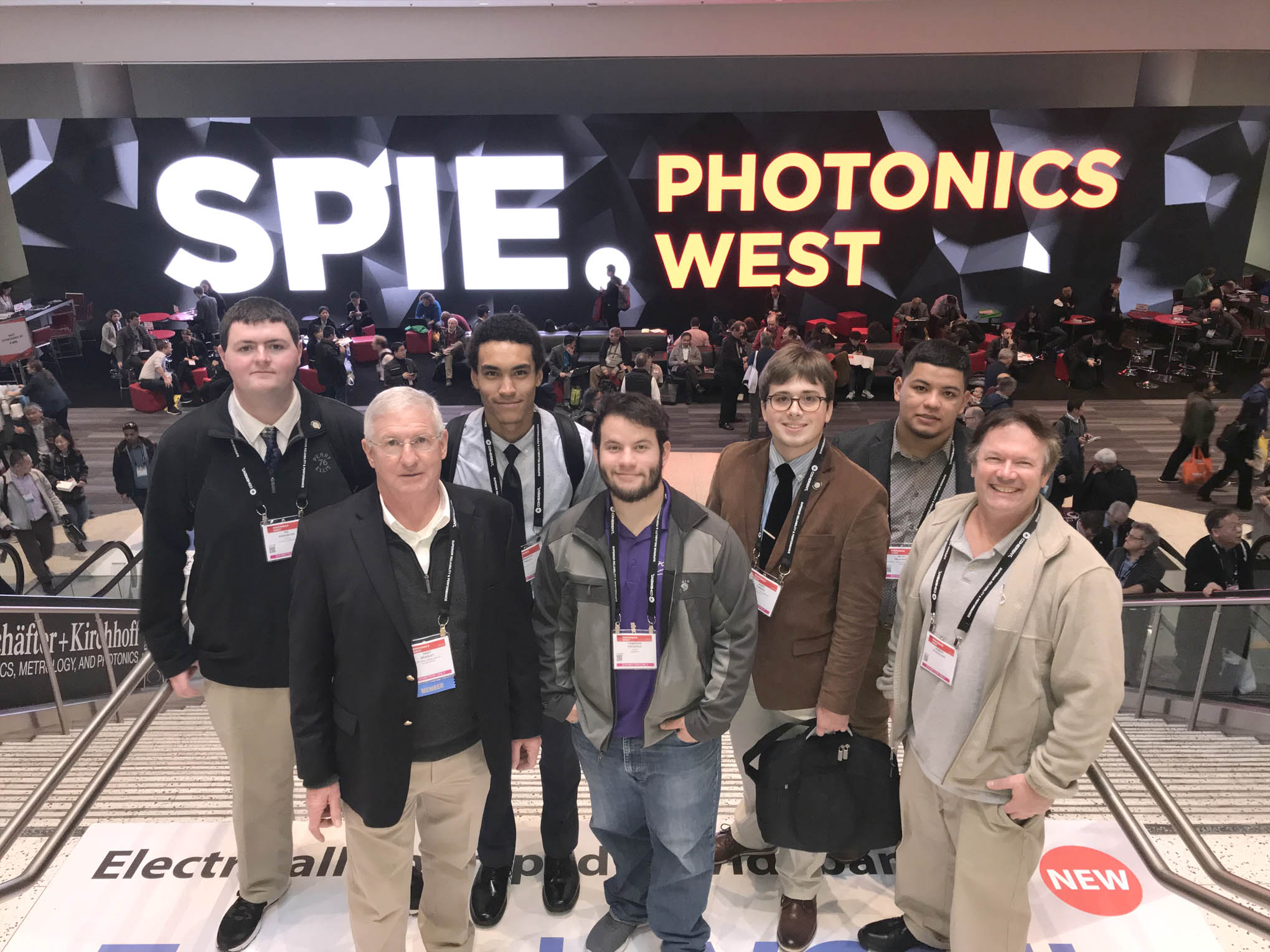 Click to enlarge,  Second-year students in the Laser and Photonics Technology program at Central Carolina Community College's Harnett Main Campus attended the 2019 SPIE Photonics West Convention in San Francisco. Pictured are, left to right: Ian Washburn, Gary Beasley (Lead Instructor), Brandon Pasley, Cameron Wiedholz, Jamie Turner, Kilvet Zalavarria, and Robert Strickland. 