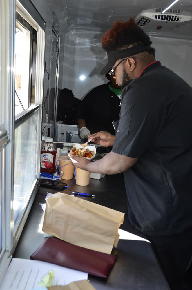 Click to enlarge,  Chef De-Ven Atkinson serves up hibachi food in the Central Carolina Community College food truck that was set up on the school's Harnett Main Campus. The truck is helping students learn how to cook away from their home kitchen at the school. 