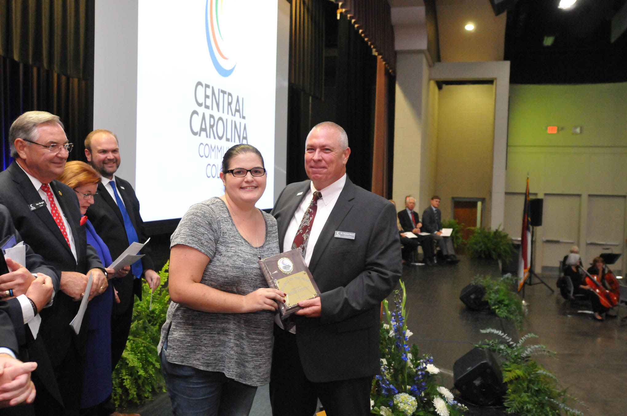 Click to enlarge,  Michelle Patterson (left), a Central Carolina Community College Veterinary Medical Technology Instructor, receives the Adjunct of the Year award from Dr. Rodney Powell (right), CCCC Executive Director of the Center for Academic Excellence, during the Convocation and Installation of Dr. Lisa M. Chapman as Sixth President of CCCC on Sept. 26. 