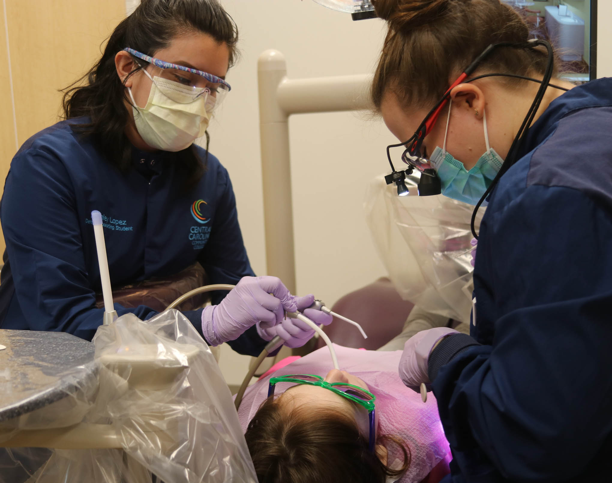 Click to enlarge,  Central Carolina Community College Dental Assisting and Dental Hygiene students place sealants on a student during Give Kids A Smile Day. 