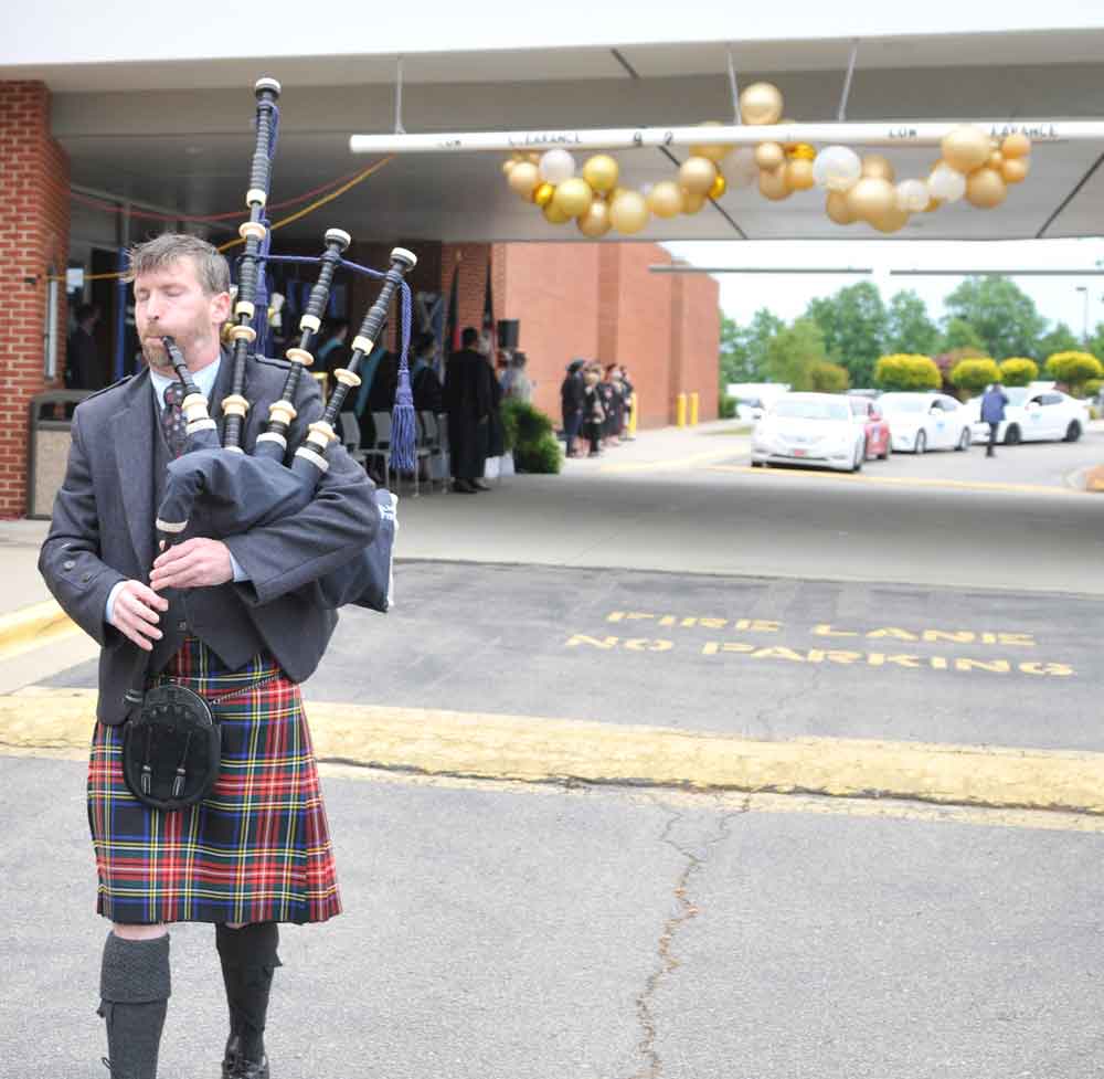 Click to enlarge,  Bagpiper Peter McArthur leads the processional music at the Central Carolina Community College graduation. 
