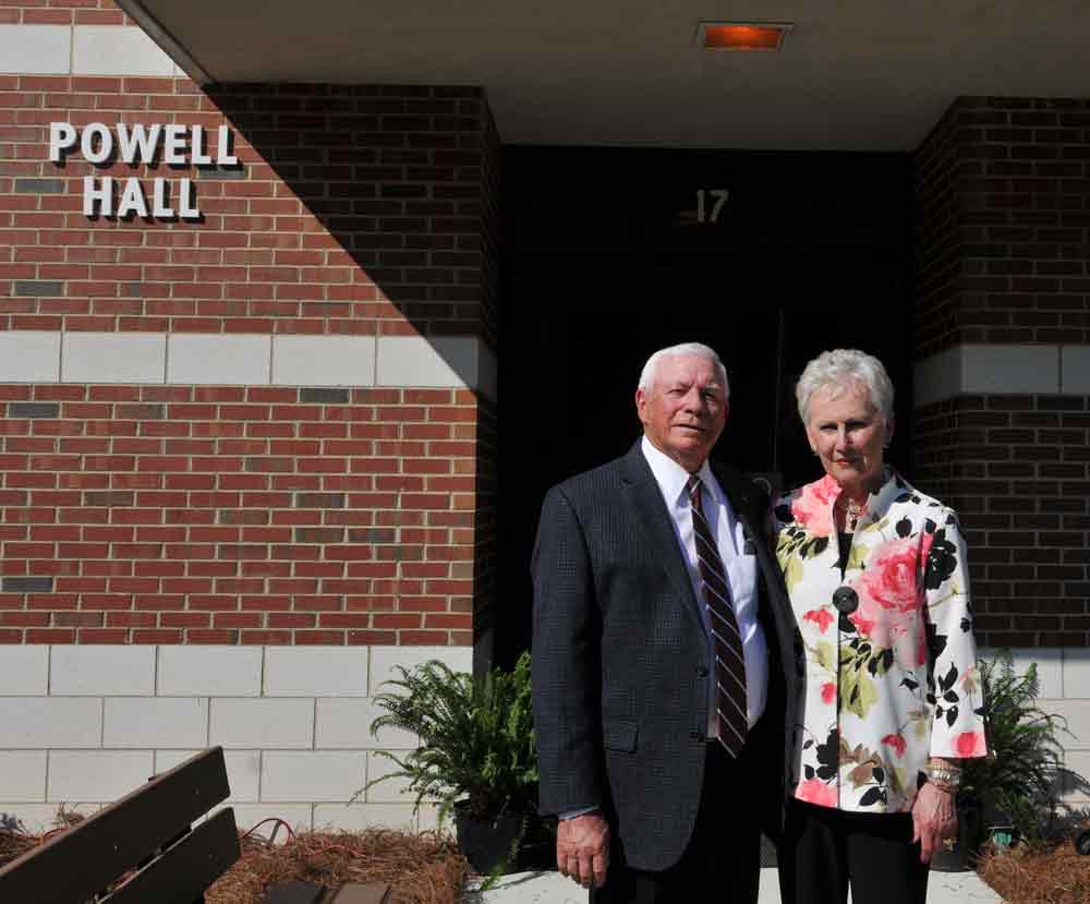 Click to enlarge,  Bobby and Linda Powell stand in front of Powell Hall on the Central Carolina Community College Lee Main Campus in Sanford. 