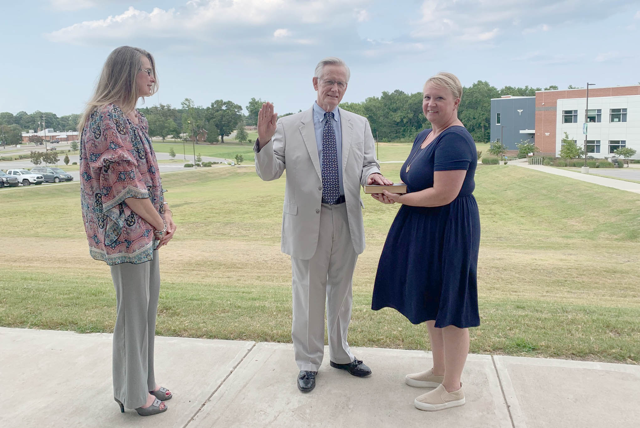Click to enlarge,  William "Bill" E. Carver Jr. (center) has been sworn in as the newest member of the Central Carolina Community College Board of Trustees. Holding the Bible for Mr. Carver is his daughter-in-law, Rachel Carver (center). Susie K. Thomas (left), Clerk of Superior Court in Lee County, conducted the ceremony.  