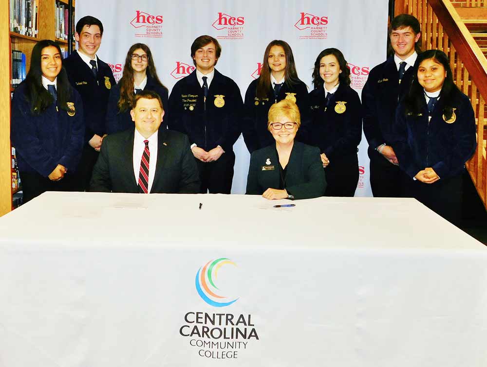 Click to enlarge,  Harnett County Schools Superintendent Dr. Aaron L. Fleming and Central Carolina Community College President Dr. Lisa M. Chapman (right) celebrate the signing of an agreement for the formation of the Harnett Agriculture Academy. Also joining the celebration are Triton High School Future Farmers of America students, left to right: Jennifer Callejas, Michael Cole, Brook Blinson, Hunter Thompson (President of THS FFA Chapter and Vice President of the South-Central Region), Camryn Conway, Allyson Hall, Caleb Smith, and Carolina Ramirez. 