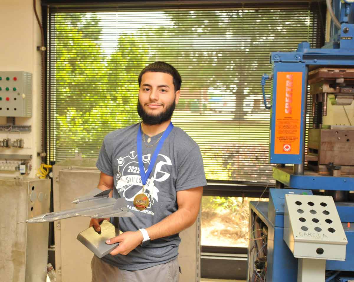 Click to enlarge,  Alex Buitrago of Central Carolina Community College, who finished first in the Welding Sculpture category in the SkillsUSA state competition, holds his entry - a replica of a SR-71 Blackbird military jet. 