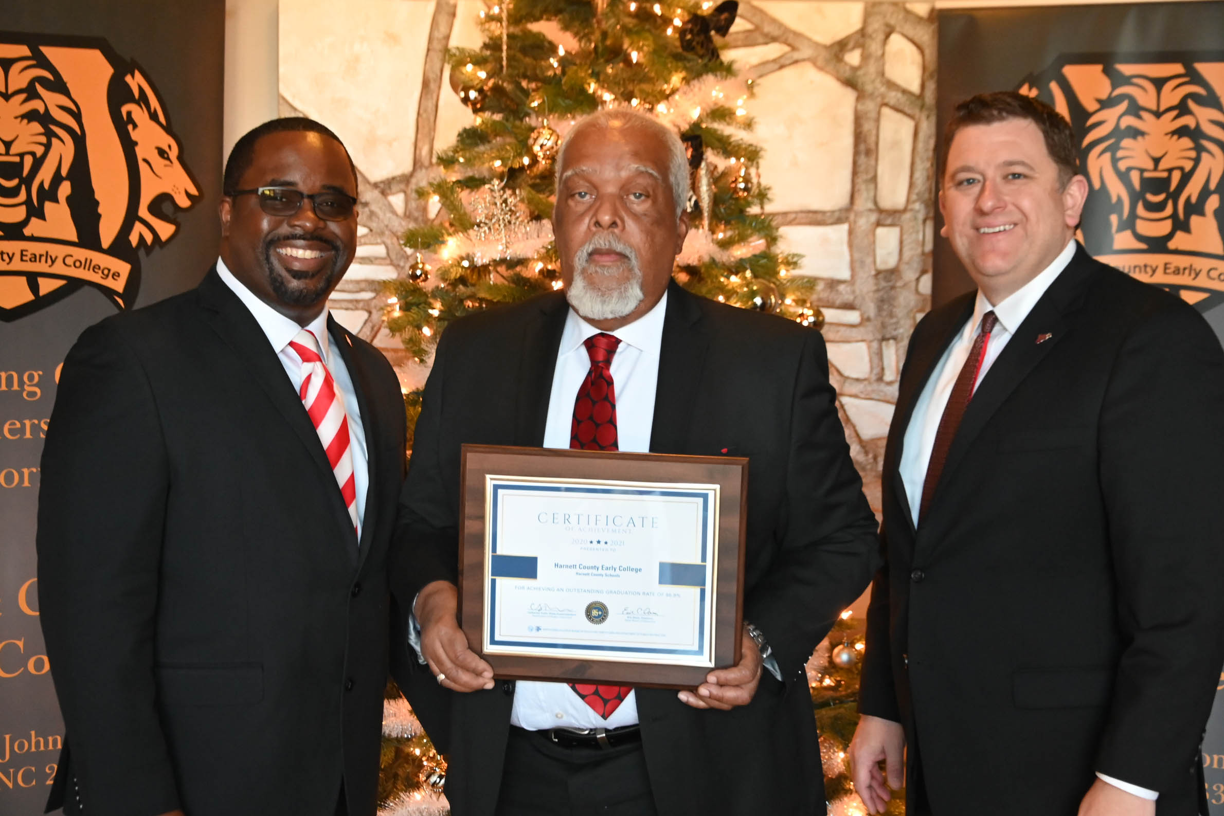 Click to enlarge,  Harnett County Early College was recognized by the N.C. Department of Public Instruction for achieving an outstanding graduation rate of 96.9 percent in 2020-2021. Pictured with a certificate recognizing the honor are, left to right: Jermaine White, Harnett County Schools Assistant Superintendent of Student Services; Walter McPherson, Principal at Harnett County Early College, and Dr. Aaron L. Fleming, Harnett County Schools Superintendent. 