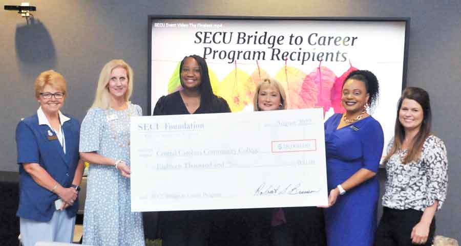 Click to enlarge,  State Employees Credit Union officials present a ceremony check to Central Carolina Community College for funds allocated for the 2022-2023 academic year. Pictured are, left to right: Dr. Lisa Chapman, CCCC President; Harriet Norris, SECU Advisory Board Member; Whitney Clarida, SECU Vice President of Sanford Branch; Jennifer Butler, SECU Vice President of Spring Lane Branch' Felicia Crittenden, CCCC Dean of Workforce Development &amp; Continuing Education Operations; and Casey Goldberg, SECU Assistant Branch Manager at the Sanford Spring Lane Branch.    