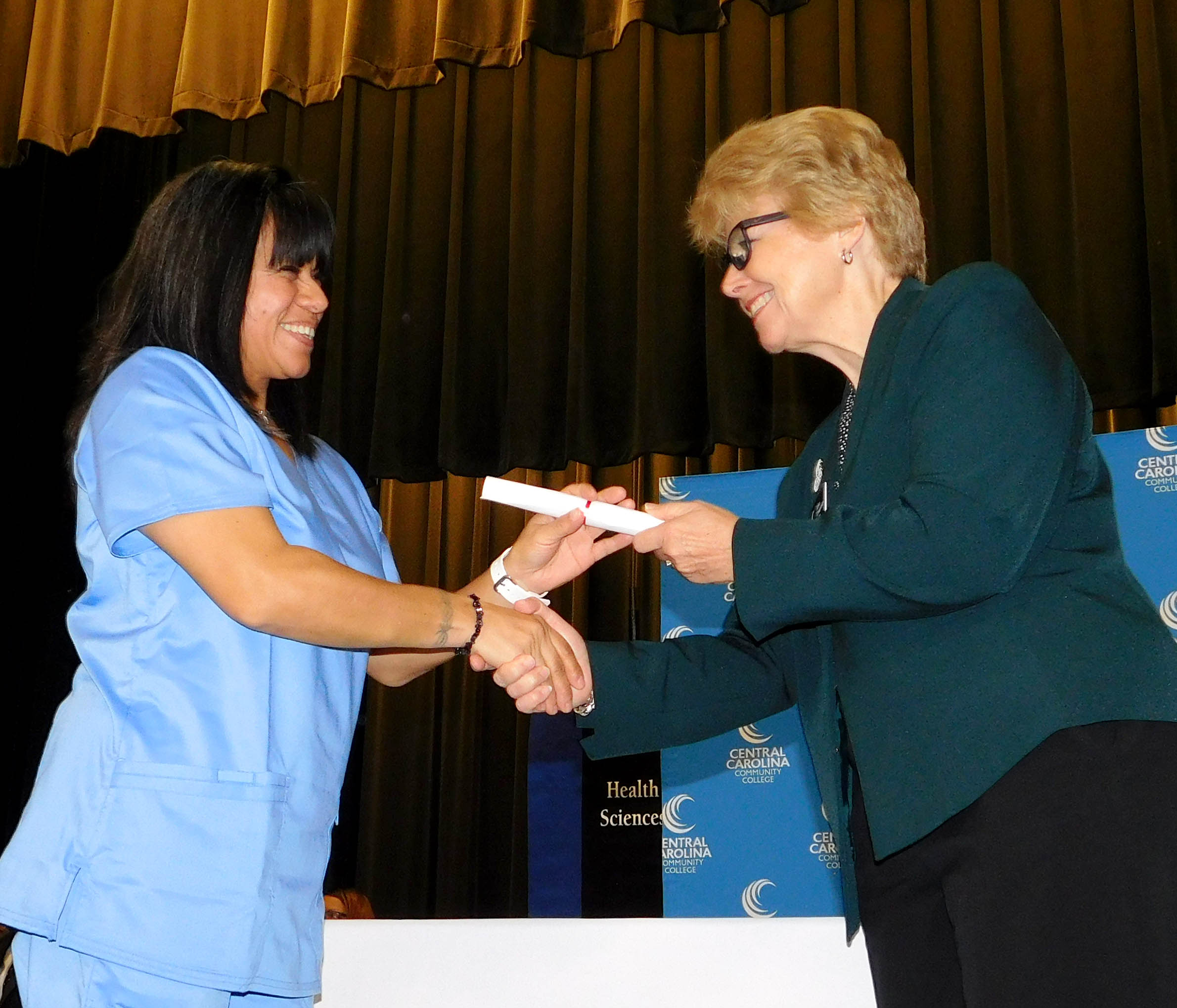 Click to enlarge,  Central Carolina Community College President Dr. Lisa M. Chapman (right) visits with one of the graduates during the CCCC Division of Workforce Development Continuing Education Health and Professional Services Programs graduation on Dec. 14. 