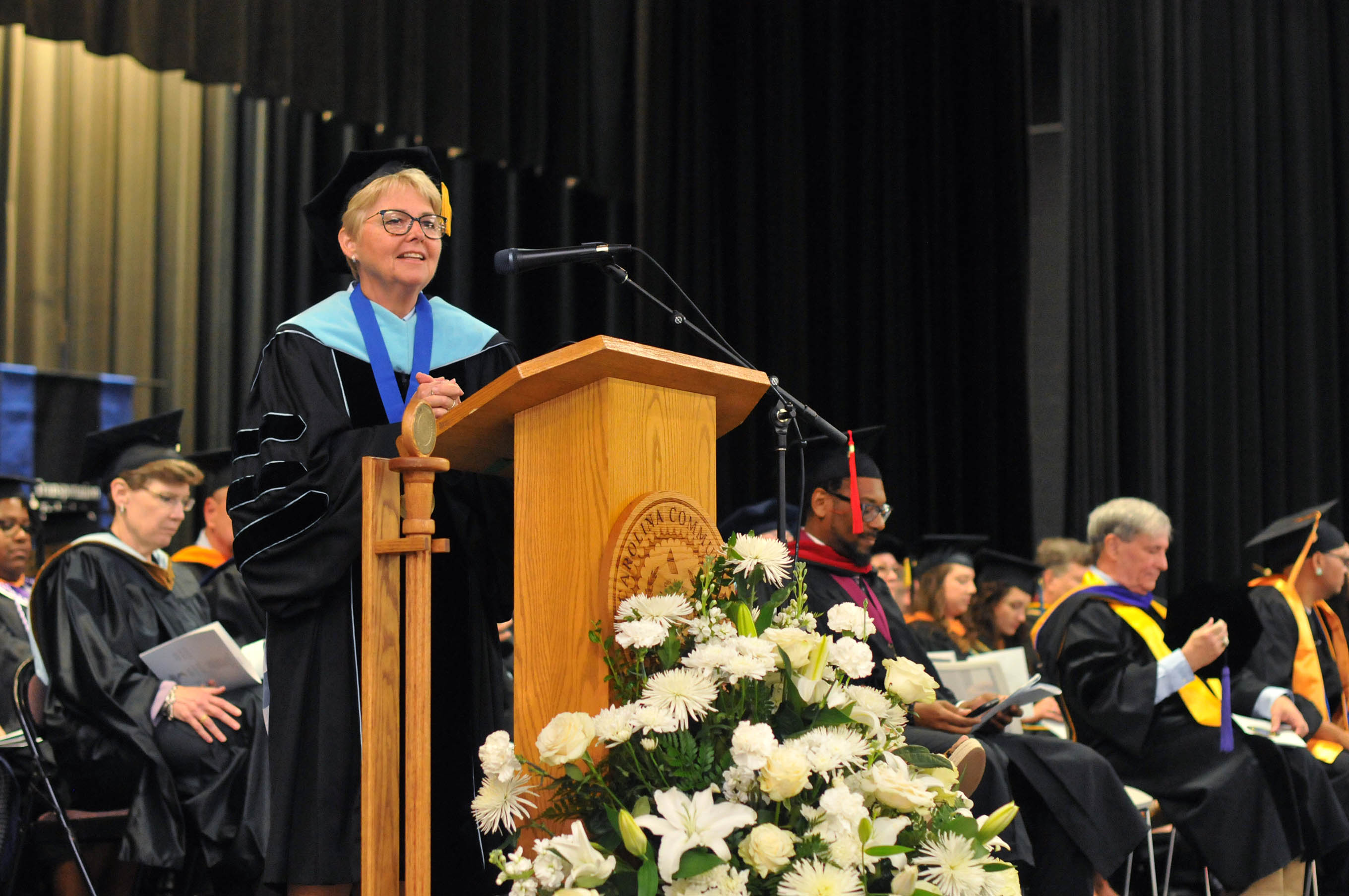 Click to enlarge,  Dr. Lisa M. Chapman, Central Carolina Community College President, speaks to graduates at the 62nd Commencement Exercises on Aug. 7 at the Dennis A. Wicker Civic &amp; Conference Center in Sanford. 