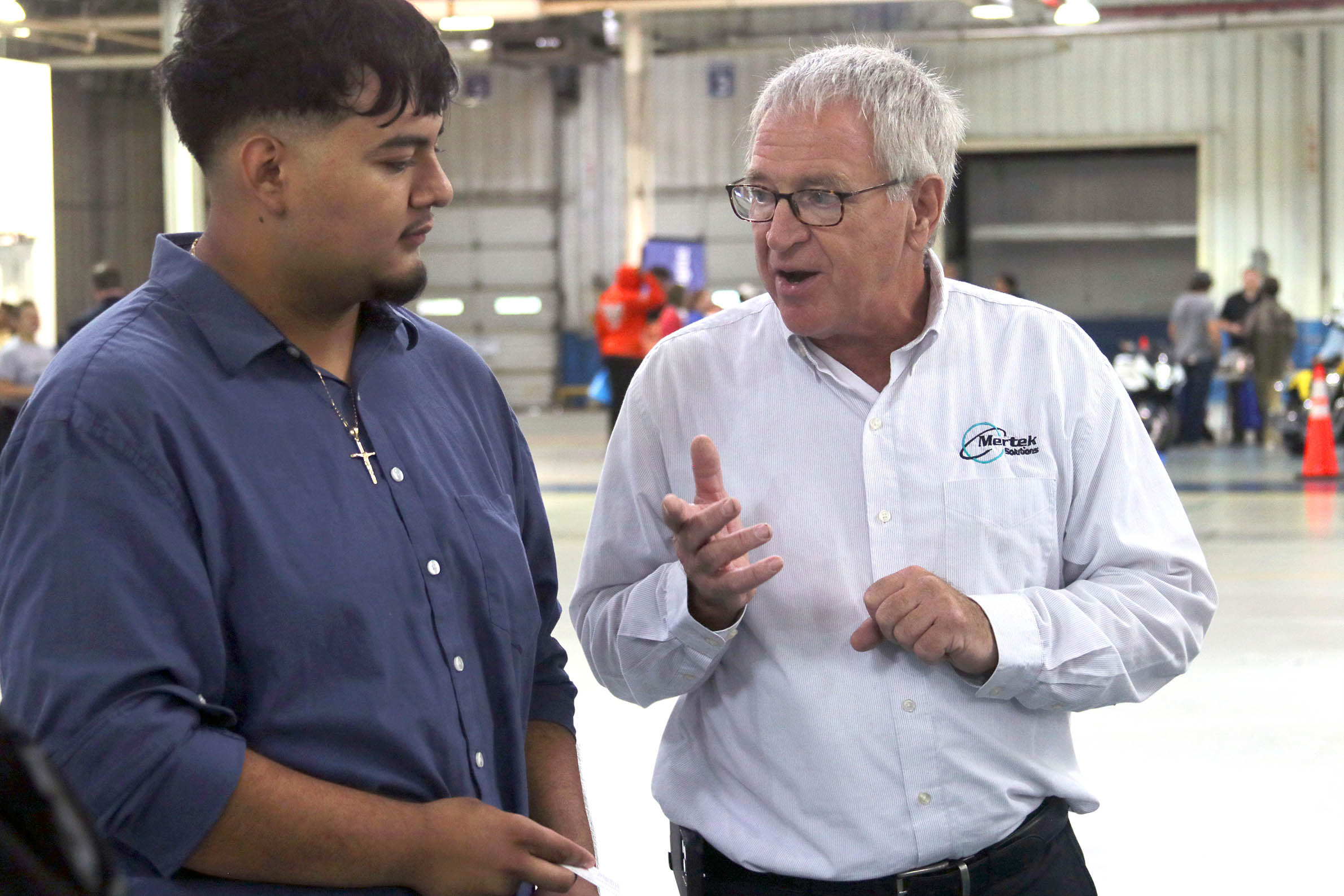 Click to enlarge,  Jerry Pedley from Mertek Solutions, right, was one of the trailblazers for Manufacturing Day when it started more than a decade ago -- inviting students to his robot manufacturing facility in Sanford. Pedley is still involved in Manufacturing Day as an exhibitor and one of the event's biggest supporters. 