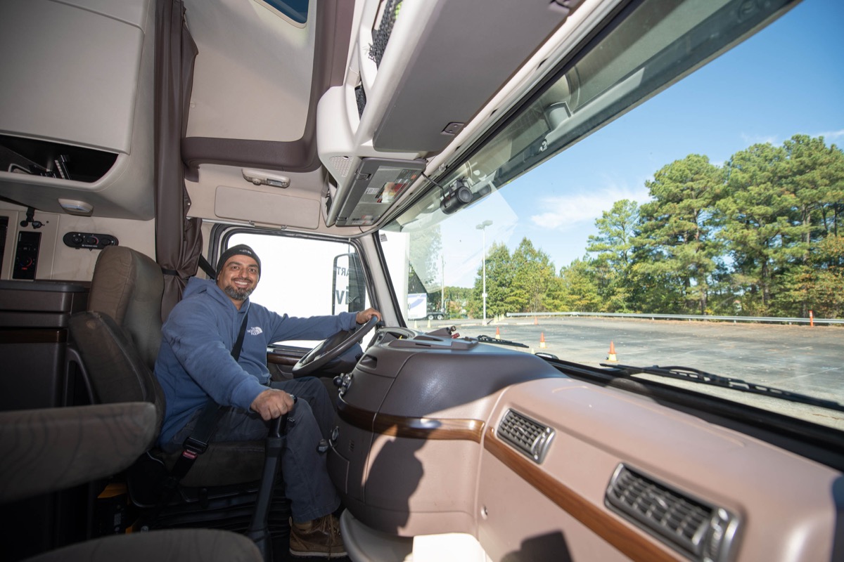 Click to enlarge,  Gilbert Riojas shows what it is like sitting in the cab of one of the trucks used in the Central Carolina Community College commercial truck driving course. 