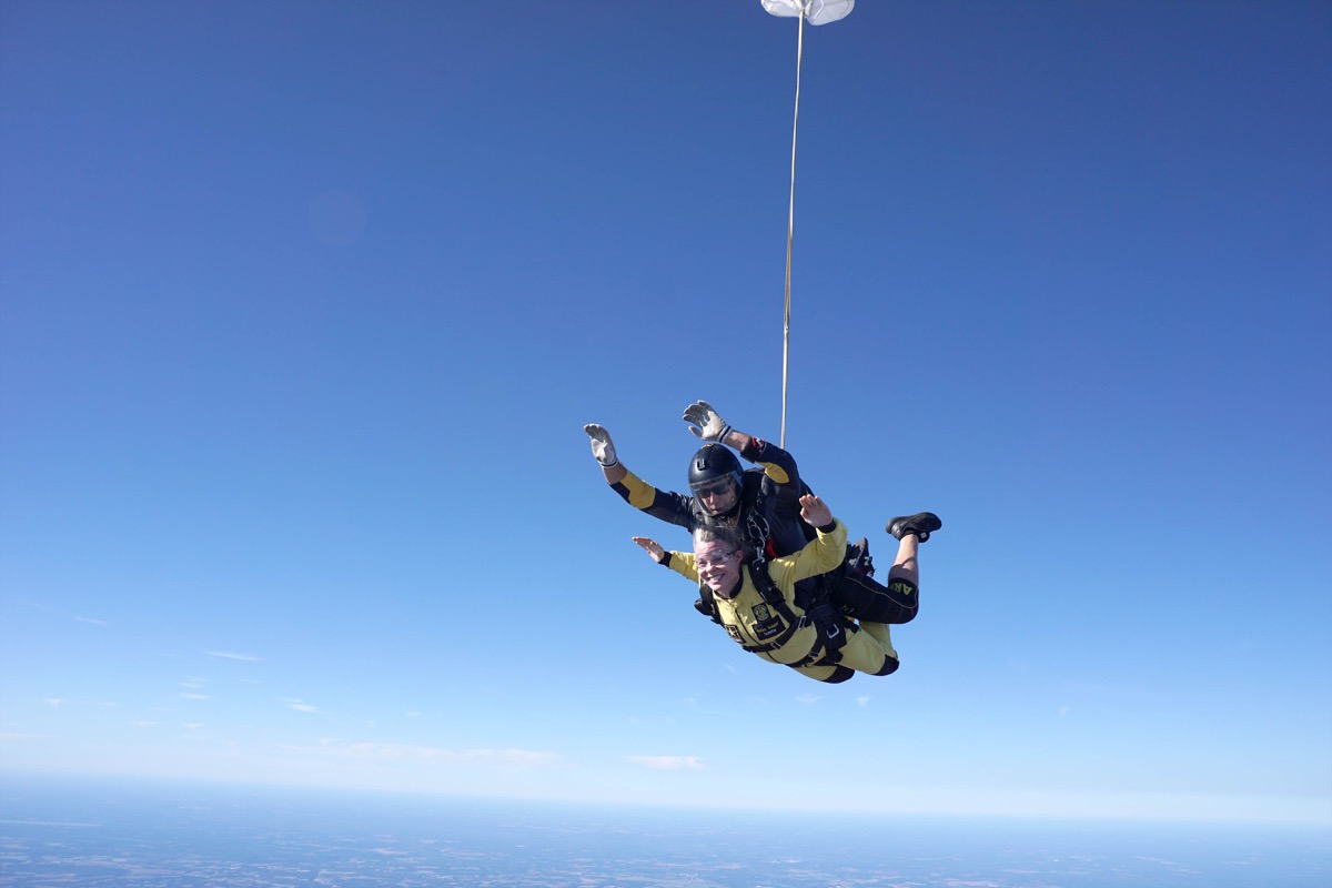 Click to enlarge,  Dr. Kristi Short, Central Carolina Community College Vice President / Chief Academic Officer, is all smiles as she glides through the air with U.S. Army Golden Knight Sergeant First Class Ryan Reis in a tandem skydive. 