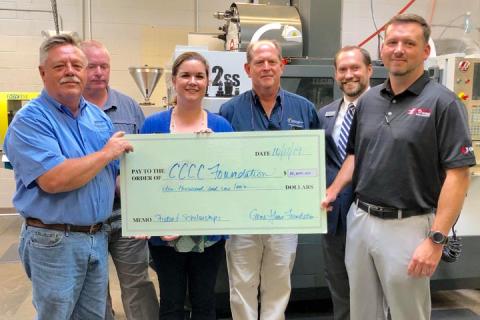 Members of the college family accepting a large donation check