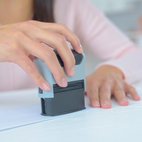 Close up image of notary stamping paperwork