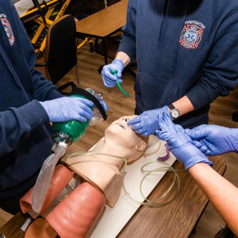 A group of students working with medical dummy