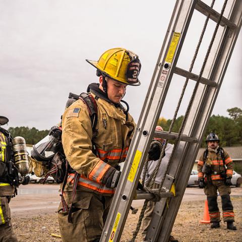 Fire Academy student securing ladder 