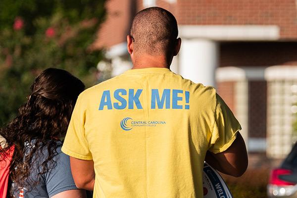 College employee wearing an"Ask Me!" shirt 