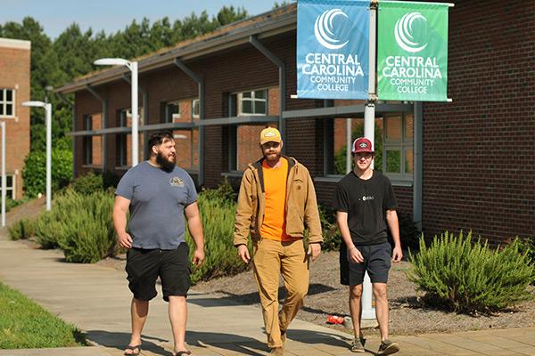 Three student walking through campus 