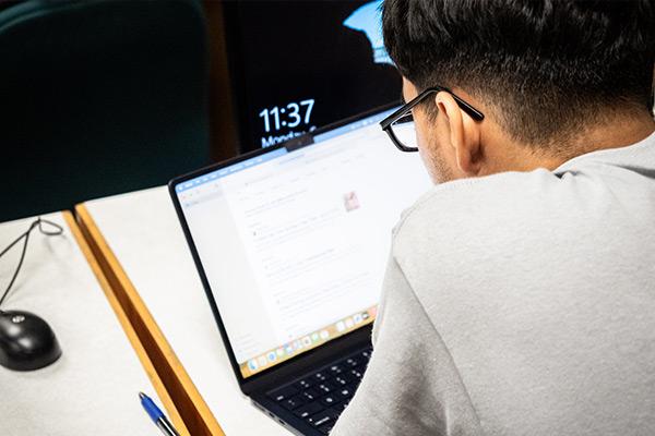 Looking over the shoulder of a student working on a laptop  