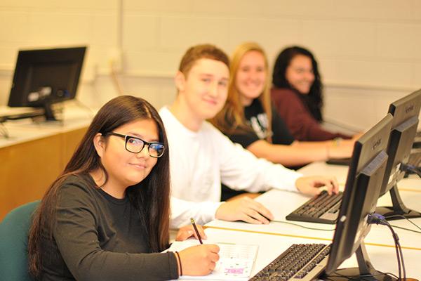 Group of students working on project at computers 