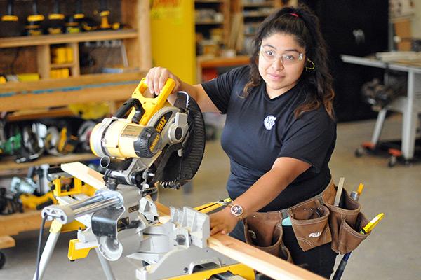 Building Construction student using miter saw