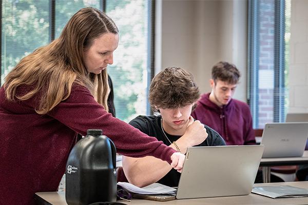 Instructor assisting student with assignment 